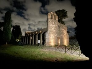 Historic stone church on the Appian Way illuminated by ground lights at night